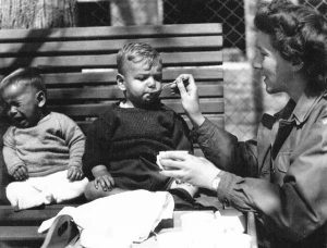 Eine UNRRA Mitarbeiterin füttert Kleinkinder im Kinderzentrum Aglasterhausen | An UNRRA worker feeds infants at the Aglasterhausen Children's Center