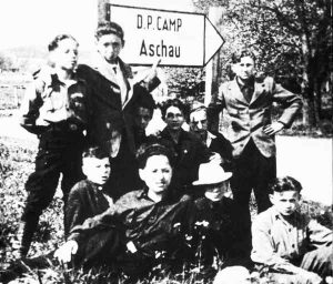 Kinder vor dem Hinweisschild zum Aschauer Children’s Center | Children in front of the sign for the Aschau DP Camp